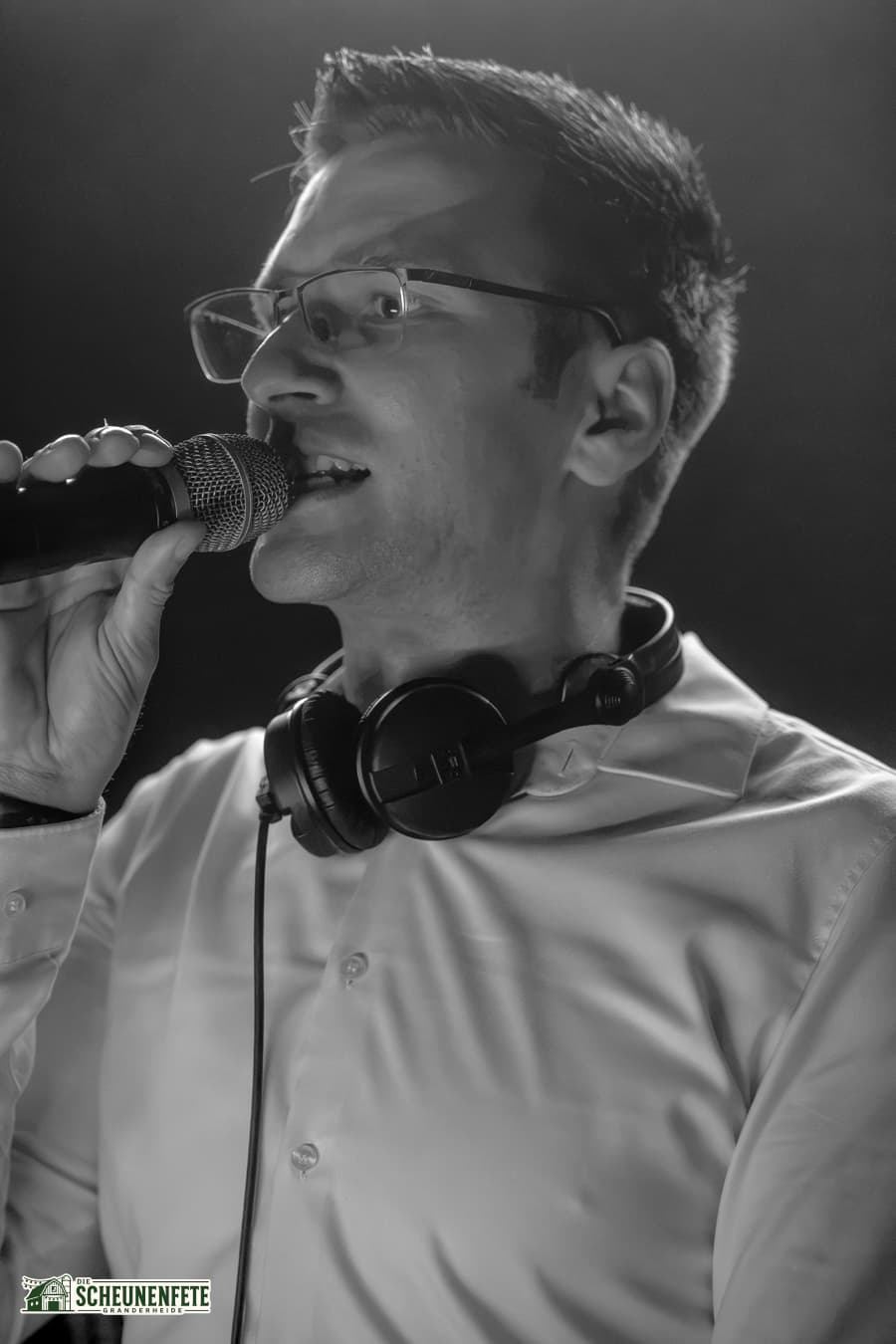 DJ mit Mikrofon und Kopfhörern — Schwarz-Weiß-Aufnahme von der Scheunenfete 2026